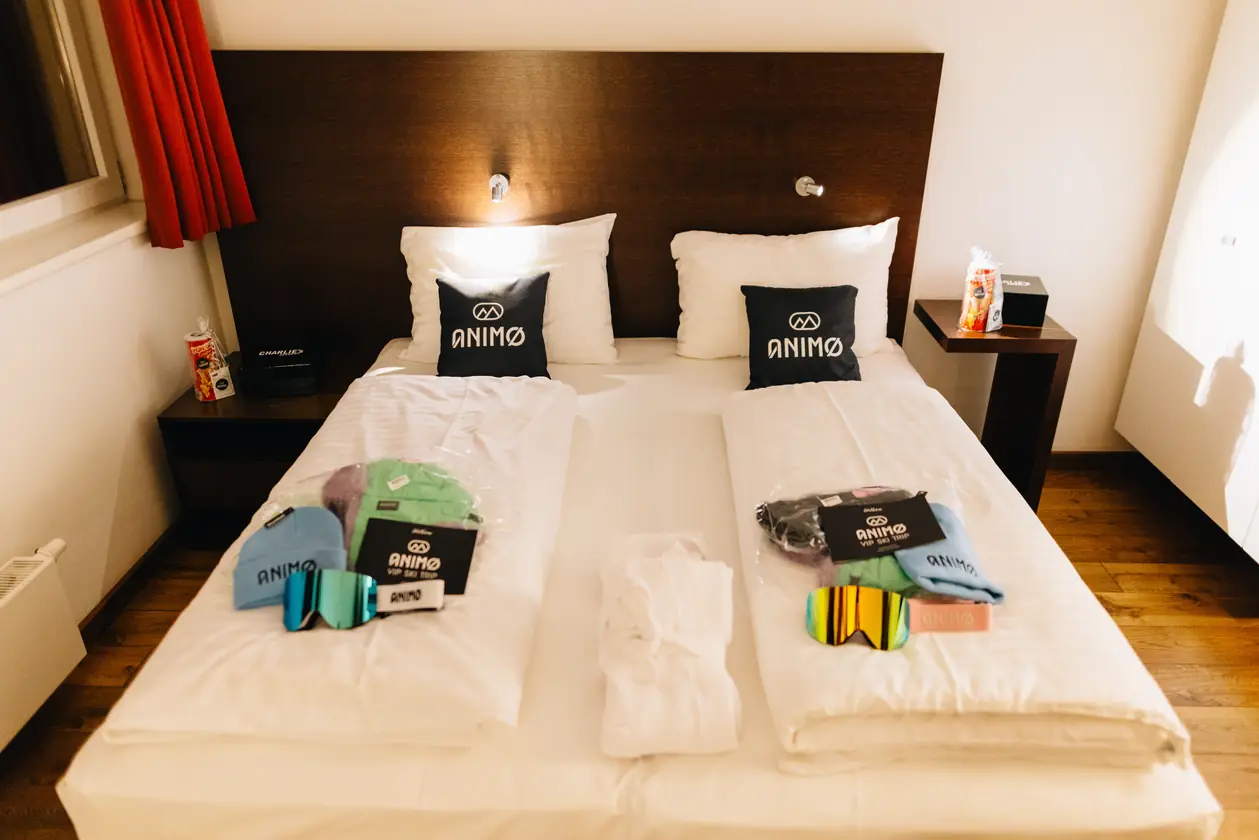 Een hotelkamer met een tweepersoonsbed en goodiebags met Animo-spullen.