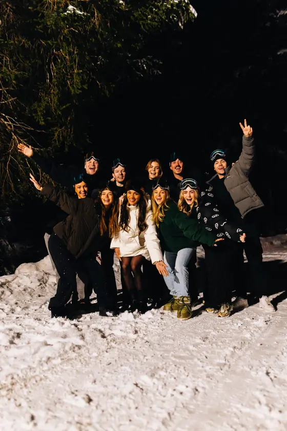 Een groep viert het feest in het donker in de sneeuw.