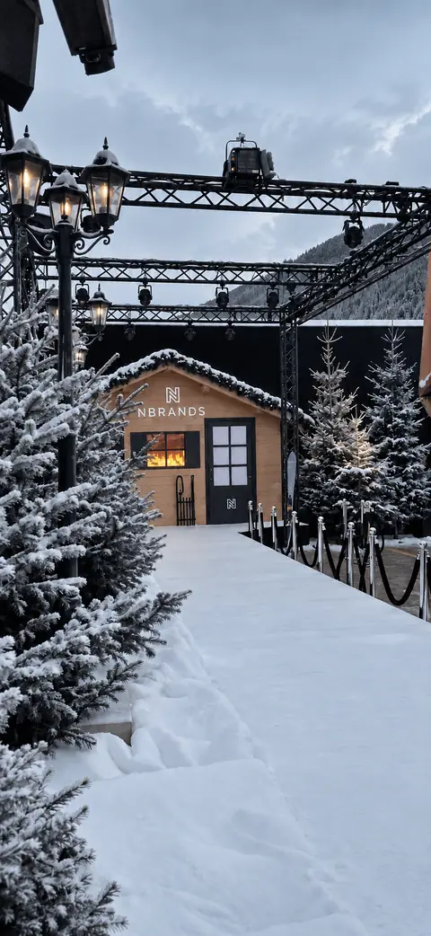 De besneeuwde ingang van een chalet met lantaarns.
