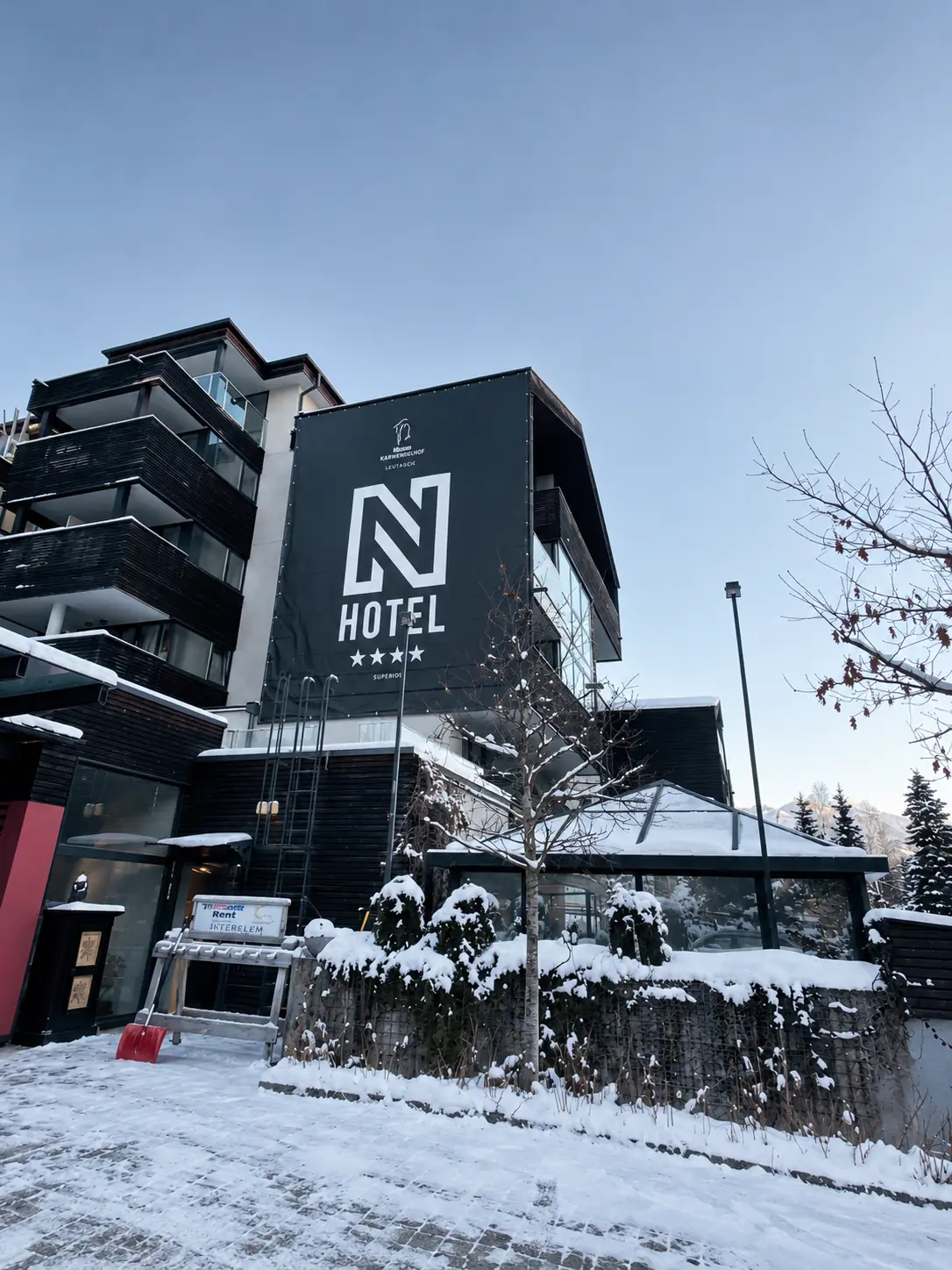 Een hotel in de sneeuw met een groot N-logo op de gevel.